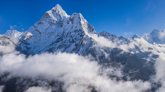 211 MPix XXXXL size panorama of Mount Ama Dablam - probably the most beautiful peak in Himalayas. 
 This panoramic landscape is an very high resolution multi-frame composite and is suitable for large scale printing
Ama Dablam is a mountain in the Himalaya range of eastern Nepal. The main peak is 6,812  metres, the lower western peak is 5,563 metres. Ama Dablam means  'Mother's neclace'; the long ridges on each side like the arms of a mother (ama) protecting  her child, and the hanging glacier thought of as the dablam, the traditional double-pendant  containing pictures of the gods, worn by Sherpa women. For several days, Ama Dablam dominates  the eastern sky for anyone trekking to Mount Everest basecamp