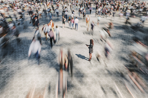 Businesswoman on the street standing in crowds of walking people. 3D generated image.