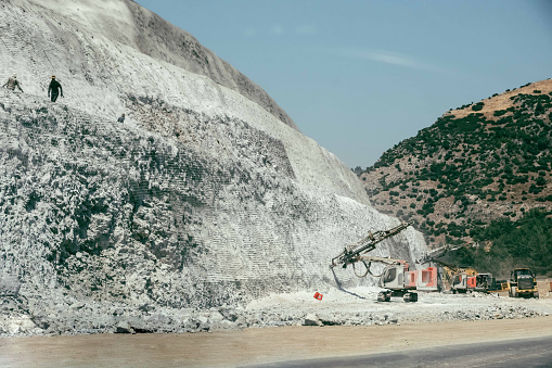 Process of concrete wall on the side of a mountain to prevent a soil and rock landslide onto the highway