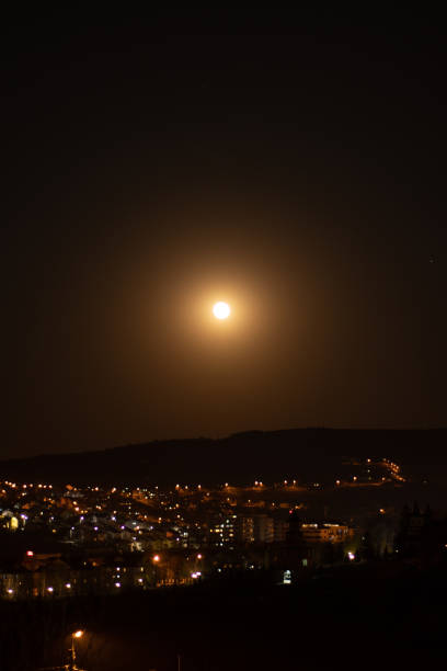 istock Fool moon at night, yellow orange sky, over the city 1912957906