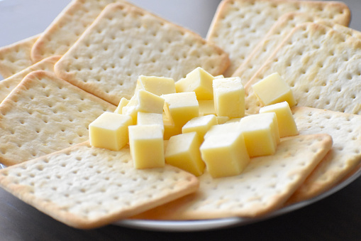 Cheese slices and crackers on a plate.