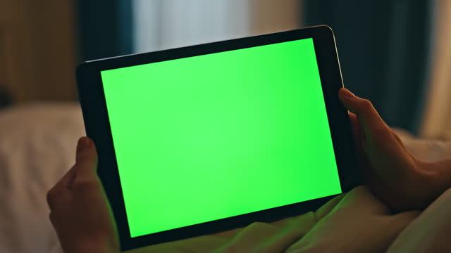 Closeup green screen tablet in hands home. Night person watch chromakey online