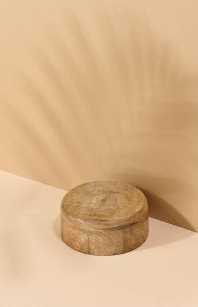 istock Round wooden platform, shadow from a palm leaf on a brown background. 1913053989