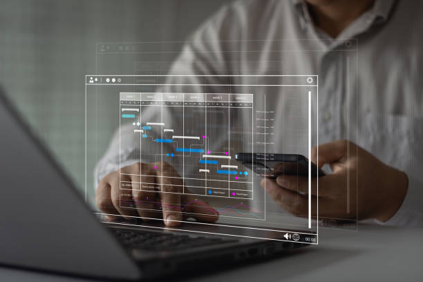 istock Project manager work with smartphone or tablet, laptop computer and update business tasks with milestones progress planning and Gantt chart scheduling timeline diagram software on a desk in the office. 1913074657