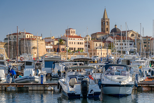 The touristic harbor of Alghero, in northwest Sardinia, with the city skyline in the background