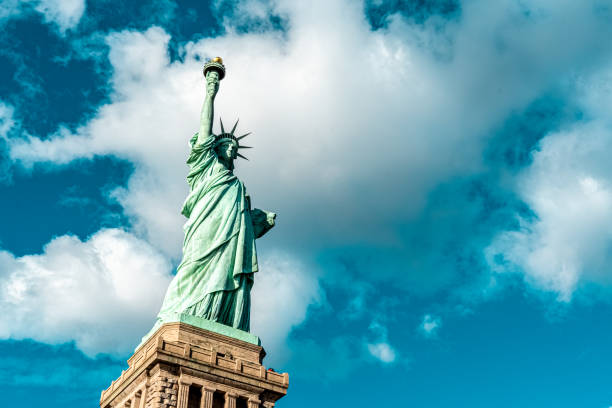 The Statue of Liberty, set against the vast expanse of the sky, stands as a symbol of freedom and hope. Its iconic silhouette, framed by the heavens, captures the enduring spirit of democracy under the open sky.