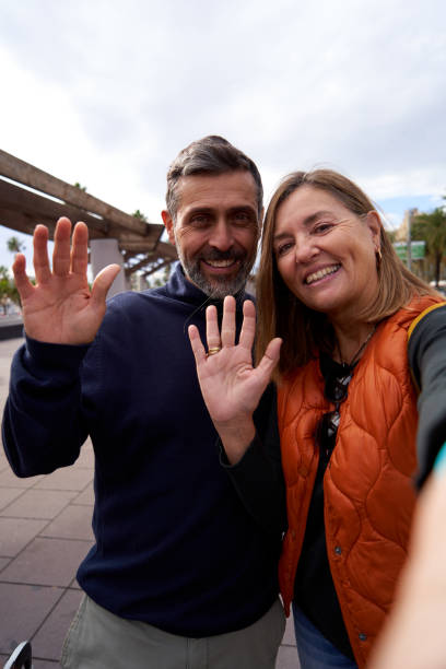 istock Smiling mature caucasian couple taking a vertical selfie outdoors using cell phone. 1913114458