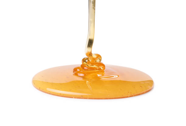 istock Pouring tasty natural honey isolated on white 1913128845