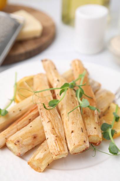 istock Plate with baked salsify roots and lemon on table, closeup 1913146885