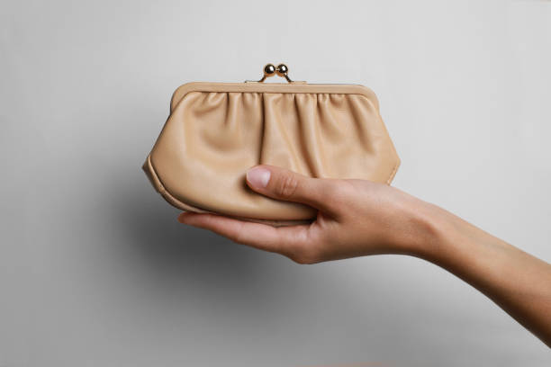 istock Woman holding leather purse on light background, closeup 1913172613