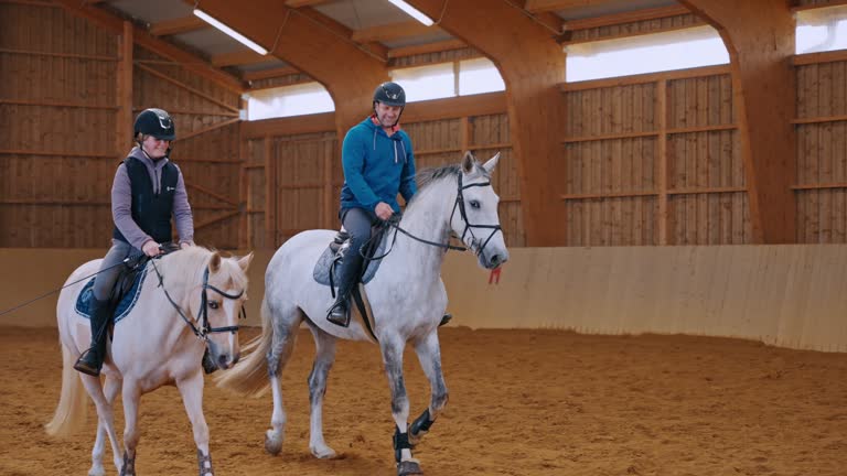 SLO MO Smiling Father and Daughter Riding White Horses in Closed Arena During Weekend