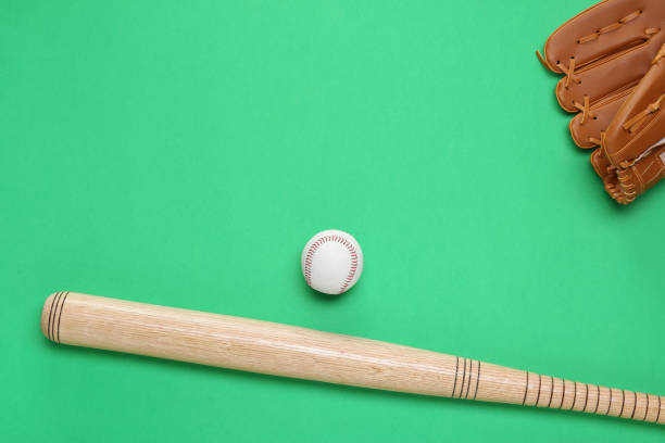 istock Baseball glove, bat and ball on green background, flat lay. Space for text 1913185967