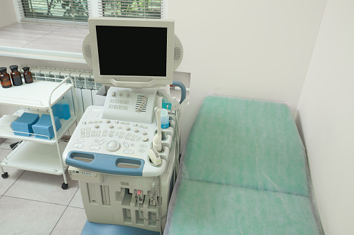 Ultrasound machine, medical trolley and examination table in hospital, above view
