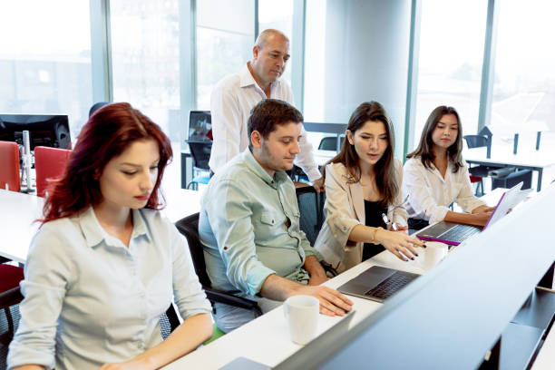 istock Dynamic Business Collaboration: Multiracial Business Team Engaged in a Productive Staff Meeting. Diverse Group  Planning Strategically, Brainstorming, Collaborating, and Working a Modern Office Setting 1913227420