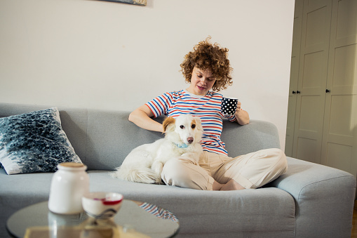 Cheerful young woman plays with her dog