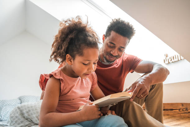 istock Mixed Race Girl Learning How To Read With Her Father At Home 1913247303