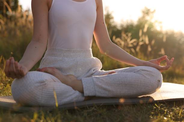 istock Woman practicing Padmasana on yoga mat outdoors, closeup. Lotus pose 1913255683