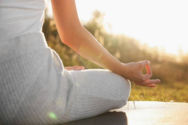 istock Woman practicing Padmasana on yoga mat outdoors, closeup. Lotus pose 1913257629