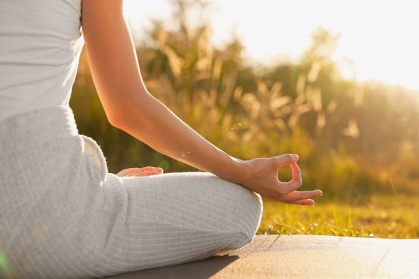 istock Woman practicing Padmasana on yoga mat outdoors, closeup. Lotus pose 1913257748