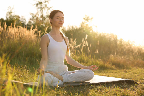 istock Beautiful woman practicing Padmasana on yoga mat outdoors, space for text. Lotus pose 1913259810