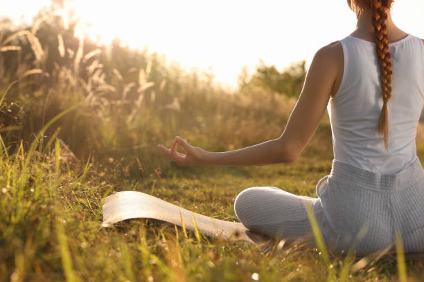 istock Woman practicing Padmasana on yoga mat outdoors, closeup with space for text. Lotus pose 1913260349