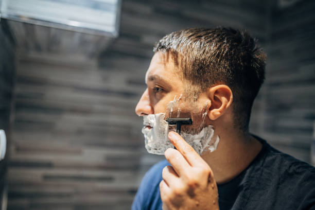istock Handsome man shaving his face in the bathroom 1913294927