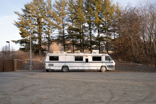 An old white RV found parked behind a fast food restaurant in Asheville, North Carolina.