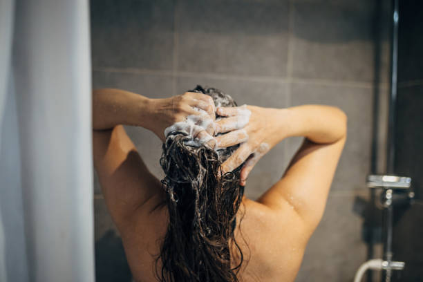 istock A young woman washes her hair 1913328257