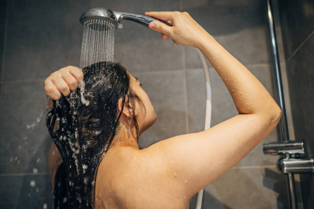 istock A young woman washes her hair 1913331395