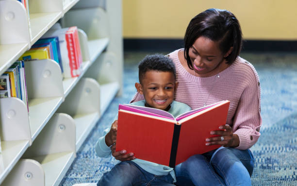 istock African-American mother, son reading in library 1913333078