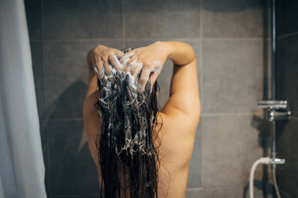 istock A young woman washes her hair 1913333095