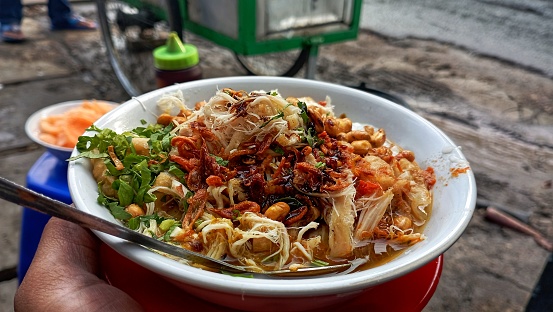 A close-up photo of the appetizing Jakarta chicken porridge street food dish, photographed in the morning in Jakarta