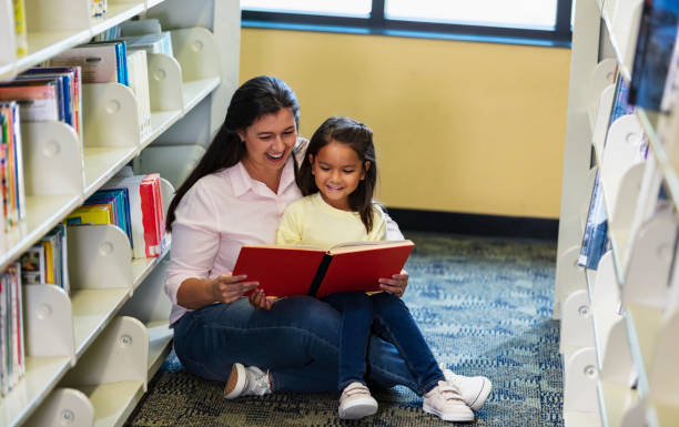 istock Mother, multiracial daughter, reading in library 1913333104