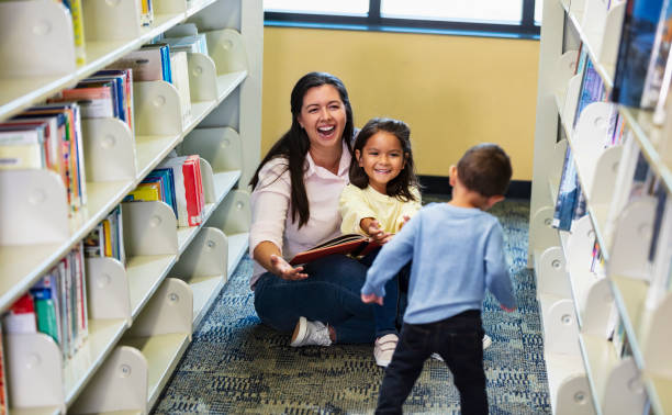 istock Mother with young children reading in the library 1913333116