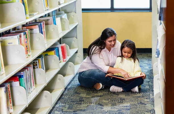 istock Mother, multiracial daughter, reading in library 1913333148