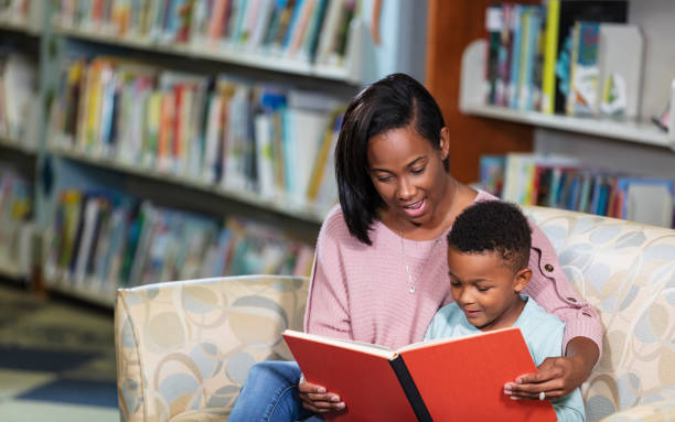 istock African-American mother, son reading in library 1913333706