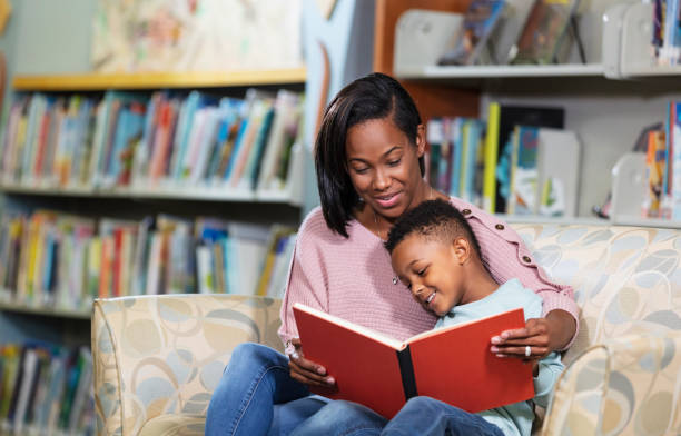 istock African-American mother, son reading in library 1913333709