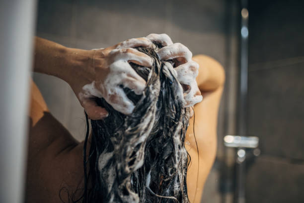 istock A young woman washes her hair 1913333726