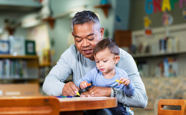 istock Asian father with toddler coloring with crayons 1913334863