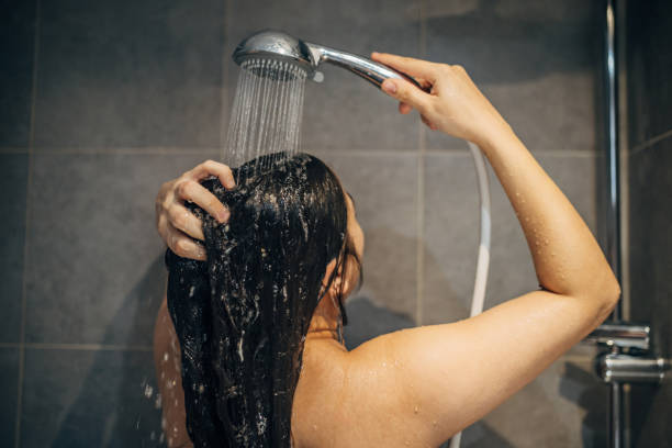 istock A young woman washes her hair 1913336040