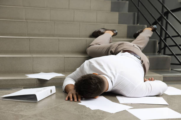 istock Unconscious man with scattered folder and papers lying on floor after falling down stairs indoors 1913338349
