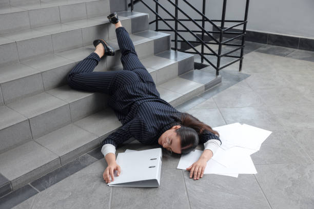 istock Unconscious woman with scattered folder and papers lying on floor after falling down stairs indoors 1913339992