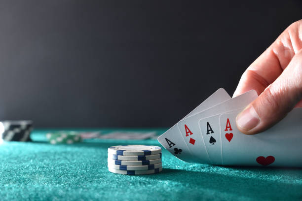 istock Hand showing four aces on green felt mat 1913355977