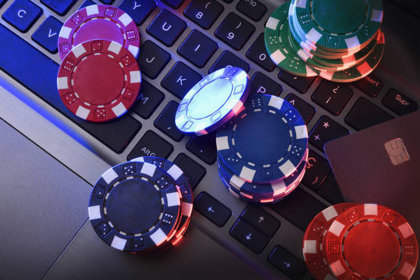Betting online games with chips on laptop keyboard and card stock photo