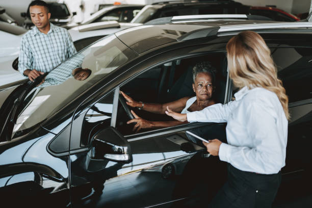 senior woman buying car with help from adult son - car old african descent car salesperson imagens e fotografias de stock