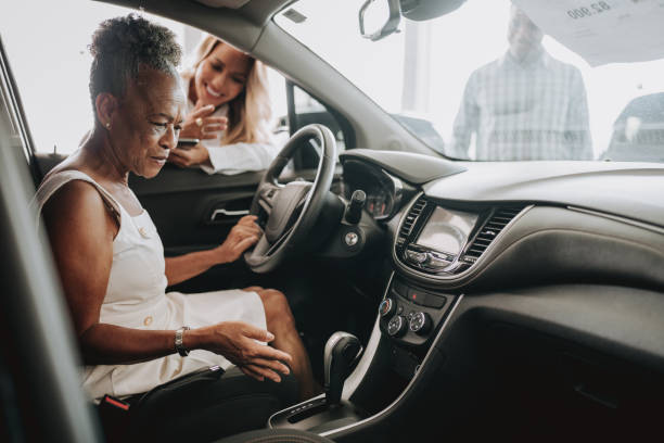 senior woman buying car - car old african descent car salesperson stock-fotos und bilder