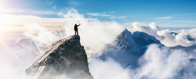 Adventurous Man Standing on top of Mountain Cliff. Extreme Adventure Composite. 3d Rendering Peak. Background Aerial Image from British Columbia, Canada.