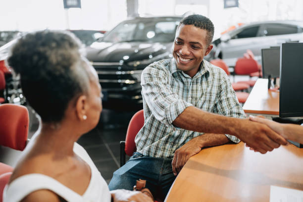 buying a car - car old african descent car salesperson zdjęcia i obrazy z banku zdjęć