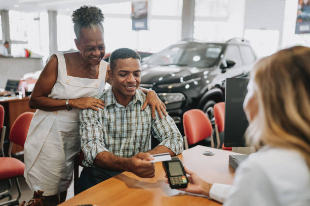 kupno samochodu płacąc kartą kredytową - car old african descent car salesperson zdjęcia i obrazy z banku zdjęć