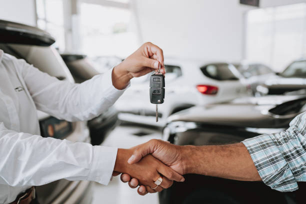 istock Handing over car keys buying a car 1913379619